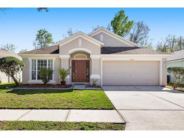 Charming single-story home featuring well-manicured landscaping, a two-car garage, and a welcoming front entrance at 5903 War Admiral Dr, Wesley Chapel, FL 33544