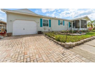 Charming single-story home featuring a paved driveway and a well-maintained lawn with beautiful stone edging at 610 Cobia Way, Oldsmar, FL 34677