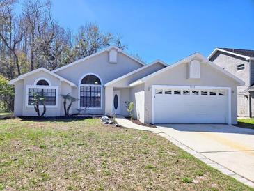 Charming single-story home with a well-manicured lawn, attached garage, and neutral color palette at 7104 Hummingbird Ln, New Port Richey, FL 34655