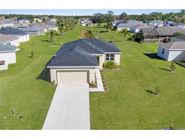 Well maintained home with a two-car garage, lush green lawn and mature trees at 8983 Wade St, Brooksville, FL 34613
