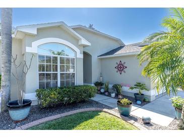 Charming home exterior with manicured landscaping, beautiful plants, and a decorative window at 11700 Leda Ln, New Port Richey, FL 34654