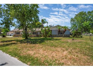 Charming single-story home featuring mature trees and a well-manicured lawn in a quiet neighborhood at 5345 Carlton Rd, New Port Richey, FL 34652