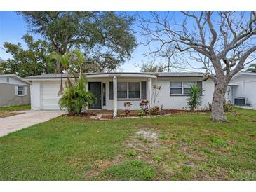 Charming single-story home with a well-maintained lawn and mature trees at 6414 Kelso Dr, Port Richey, FL 34668