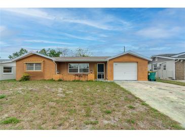 Charming single-story home features an attached garage and a well-maintained front yard at 10736 Queens Rd, Port Richey, FL 34668