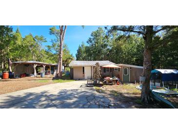 Cozy single-story home featuring a stone chimney, covered picnic area, and rustic charm at 11617 Duda Rd, Hudson, FL 34667
