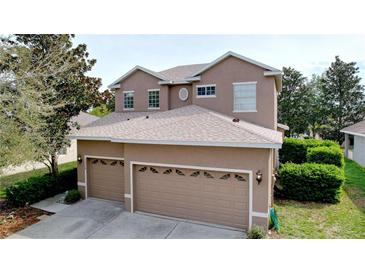 Two story home featuring an attached two car garage, neutral color scheme, and well maintained landscaping at 13304 Mandalay Pl, Spring Hill, FL 34609