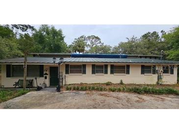 Single story home with metal roof, trimmed windows, and mature landscaping at 17932 Wendy Sue Ave, Hudson, FL 34667