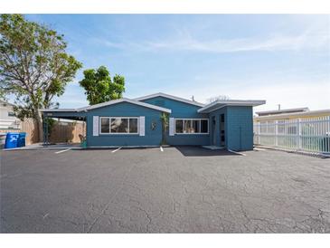 Charming blue home featuring white shutters, a carport, and ample parking space in front at 291 115Th Ave, Treasure Island, FL 33706