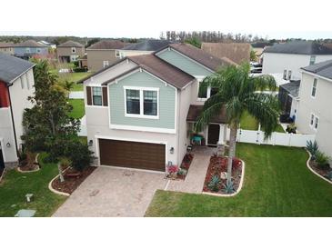 Charming two-story home with a well-manicured lawn, brick driveway and a beautiful palm tree in the front yard at 11611 Lake Blvd, New Port Richey, FL 34655