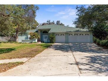 Charming single Gathering home with three-car garage, manicured landscaping, and a beautiful lawn at 13819 Eagles Rock Ct, Hudson, FL 34667