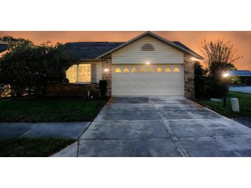 Home featuring well-maintained garage and nice landscaping under an evening sky at 4707 Wallingford Ct # 4707, New Port Richey, FL 34655