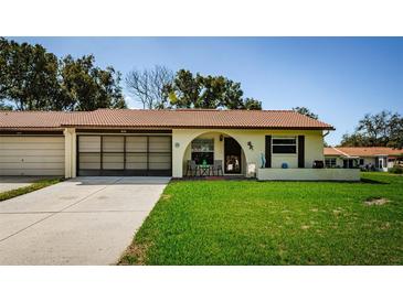 Charming single-story home with a clay tile roof and a well-manicured front lawn at 8110 Bismark Ct, Port Richey, FL 34668