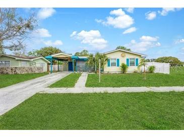 Exterior shot of charming home with a spacious lawn, driveway, and colorful accents at 4544 Cynthia Ln, Spring Hill, FL 34606