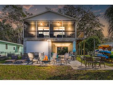 Inviting two-story home with a garage, screened porch, patio, and outdoor seating around a fire pit at 6183 Waverly Rd, Weeki Wachee, FL 34607