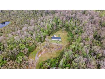 Beautiful aerial view of home nestled on wooded lot with mature trees and in-ground pool at 13024 Mohican Ave, New Port Richey, FL 34654