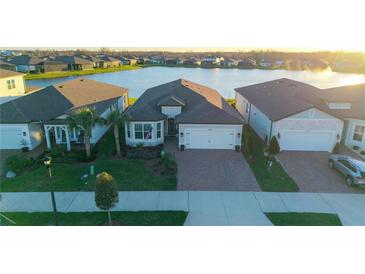 Beautiful single Gathering home showcasing a brick paved drive, meticulous landscaping, and tranquil waterfront views at 19742 Sea Glass Cir, Land O Lakes, FL 34638