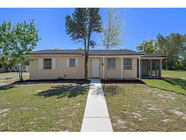 Charming single-story home with manicured lawn, screened porch, and bright exterior paint at 520 Copperfield Rd, Spring Hill, FL 34606