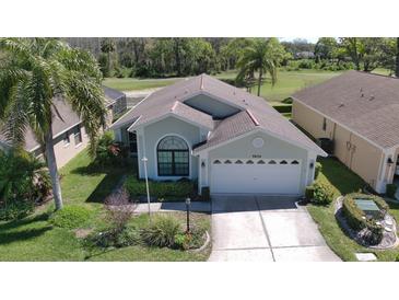 Charming single-story home featuring a manicured lawn and attached two-car garage at 9634 Green Needle Dr, New Port Richey, FL 34655