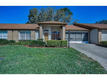 Charming single-story home featuring a well-manicured lawn and a cozy front porch with attractive landscaping at 9713 Sweeping View Dr, New Port Richey, FL 34655