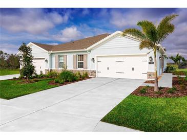Charming single-Gathering home boasts a well-manicured lawn and an inviting two-car garage and light blue accents at 285 Voltaire Dr, Spring Hill, FL 34609