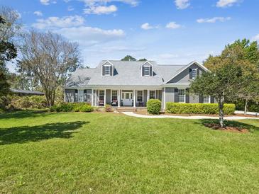Charming single-Gathering home with a well-manicured lawn, a welcoming front porch, and attractive landscaping at 3733 Wiregrass Rd, New Port Richey, FL 34655