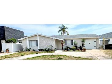 Charming single-story home featuring a stone facade, attached garage, and well-maintained landscaping at 4030 Grayton Dr, New Port Richey, FL 34652
