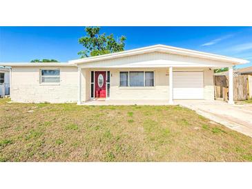 Charming single-story home featuring a red front door and attached garage, perfect for comfortable living at 4938 Fruitwood Loop, Holiday, FL 34690