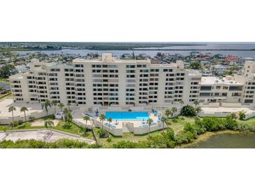 Beautiful condo building featuring a pool with surrounding lounge chairs and landscaped greenery at 5915 Sea Ranch Dr # 211, Hudson, FL 34667
