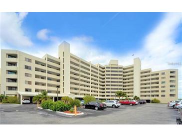 A multi-story building with parking and tropical landscaping under a partly cloudy sky at 6035 Sea Ranch Dr # 411, Hudson, FL 34667
