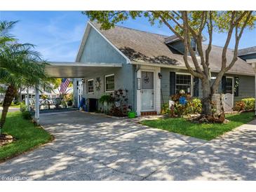 Charming home features a covered carport, mature trees, and beautifully landscaped front yard at 6710 Devonshire Ln # 10A, New Port Richey, FL 34653
