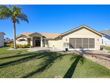 Charming single-story home with lush lawn, screened garage, and meticulously landscaped front yard at 8609 Regal Ln, Hudson, FL 34667