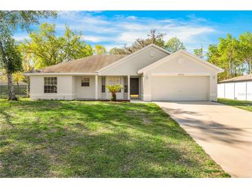 Charming single-story home featuring a well-maintained lawn and attached two-car garage at 10322 Elnora St, Spring Hill, FL 34608