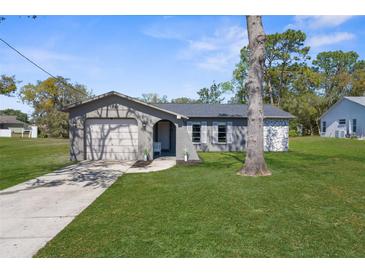 Charming single-story home featuring a well-manicured lawn and an attached garage at 1283 Coble Rd, Spring Hill, FL 34608