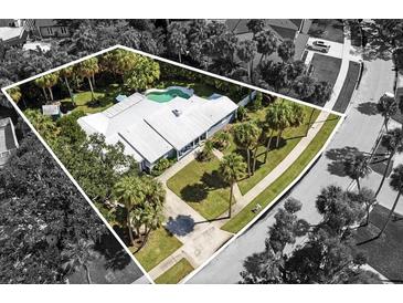 An aerial view of a beautiful home, tropical landscaping, and a sparkling swimming pool at 2606 S Hawthorne Cir, Tampa, FL 33629