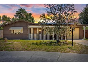 Charming home featuring a manicured lawn, a white picket fence, and lovely exterior lighting at 3728 Linkwood St, New Port Richey, FL 34652