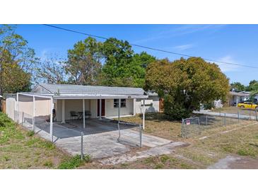 Charming single-story home featuring a covered carport and fenced front yard on a sunny day at 4743 Foothill Dr, Holiday, FL 34690