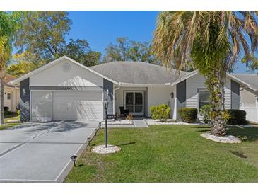 Charming single-story home boasts a well-manicured lawn, beautiful landscaping, and a welcoming facade at 7305 Sugarbush, Spring Hill, FL 34606