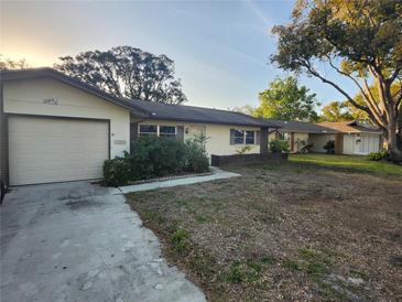 Charming single-story home with a one car garage and a traditional front yard landscape at 10803 Hachita Dr, Port Richey, FL 34668