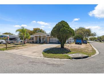 Charming one-story home featuring a well-maintained lawn and a circular driveway at 7514 Bergamot Dr, Port Richey, FL 34668