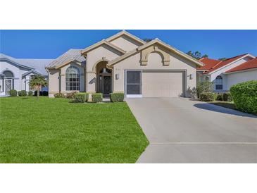 Charming single-story home with a well-manicured lawn, a two-car garage, and an arched entryway at 9131 Rhett Ln, Weeki Wachee, FL 34613