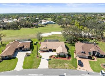 Stunning aerial view of a home with a tile roof overlooking a lush golf course at 9630 Southern Belle Dr, Weeki Wachee, FL 34613