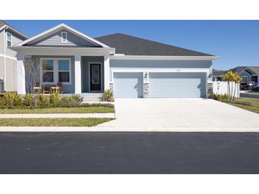 Charming single-story home featuring a two-car garage and manicured landscaping, creating an inviting curb appeal at 1436 Gopher Loop, Tarpon Springs, FL 34689