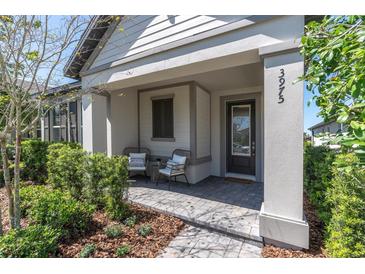 Inviting covered front porch with stylish seating and a paved walkway to the front door at 3975 Night Star Trl, Odessa, FL 33556