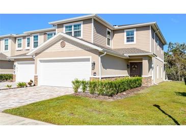 Charming two-story townhome featuring an attached garage, neutral color palette, and well-maintained landscaping at 5360 Riverwalk Preserve Dr, New Port Richey, FL 34653