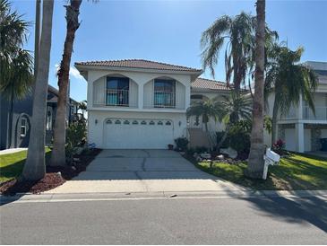 Two-story home featuring a 2-car garage, arched balconies and well manicured landscaping at 5956 Seaside Dr, New Port Richey, FL 34652
