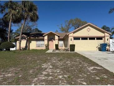 Charming single-story home featuring a two-car garage and tropical landscaping at 7167 Landmark Dr, Spring Hill, FL 34606