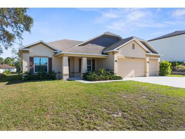Lovely one-story residence with a three-car garage, attractive landscaping, and a welcoming entrance at 12450 Fish Cove Dr, Spring Hill, FL 34609