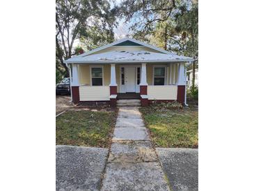 Charming bungalow with a red and yellow facade, inviting front porch, and traditional architectural details at 315 Highland St, Brooksville, FL 34601