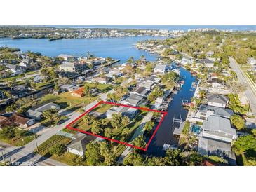 An aerial view showcases a charming single-story home with access to a canal and lush greenery at 5435 Quist Dr, Port Richey, FL 34668