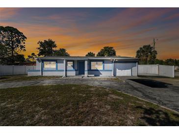 Charming single Gathering home, front view with driveway and sunset, featuring mature trees and inviting curb appeal at 6250 Vermont Ave, New Port Richey, FL 34653